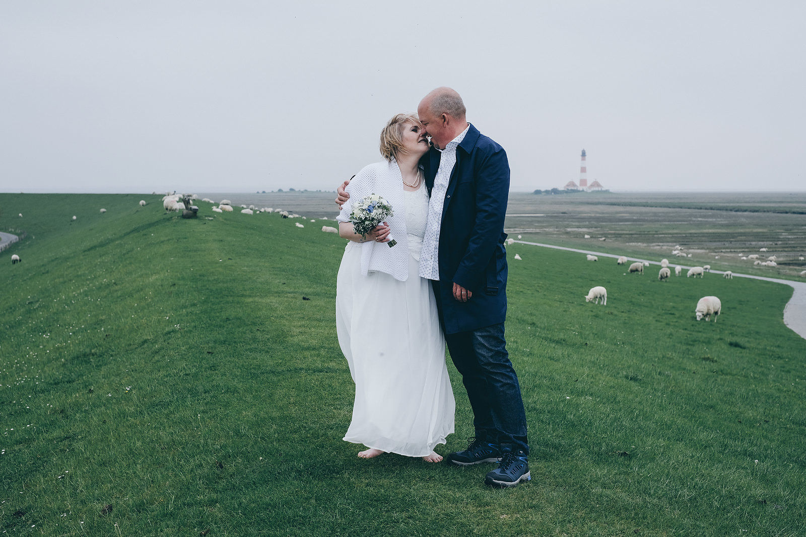 Hochzeitsfotograf Brautpaar am Deich in Sankt Peter-Ording Westerhever Nordfriesland Leuchtturm und Schafe