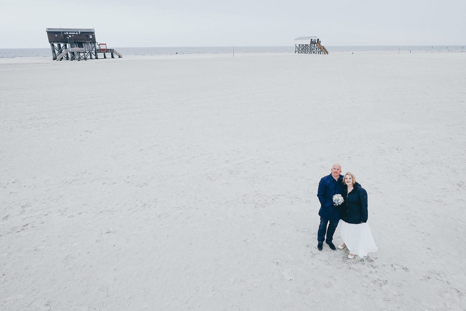 Hochzeitsfotograf Brautpaar am Strand Pfahlbauten in Sankt Peter-Ording Hochstativ Panorama