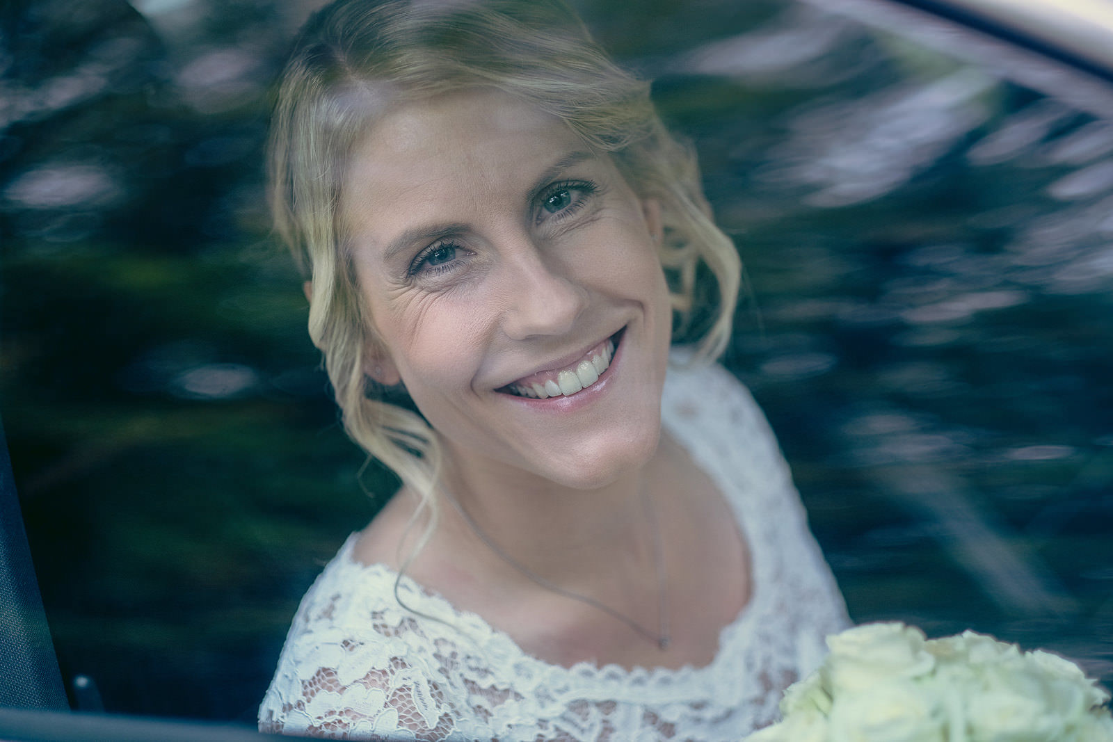 Hochzeitsfotograf Braut im Auto kommt an im Regen Herbst