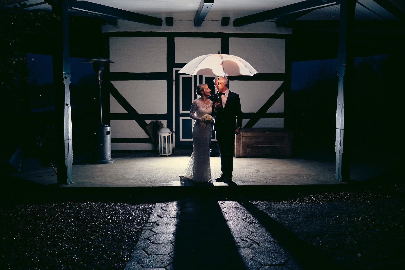 Hochzeitsfotograf Hochzeitsfoto im Regen Brautpaar mit Schirm Kreatives Hochzeitsfoto
